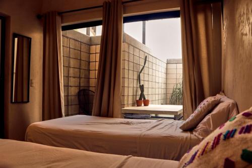 a bedroom with two beds and a window at Casa Nomada Tuxtla Hotel - Hostal in Tuxtla Gutiérrez