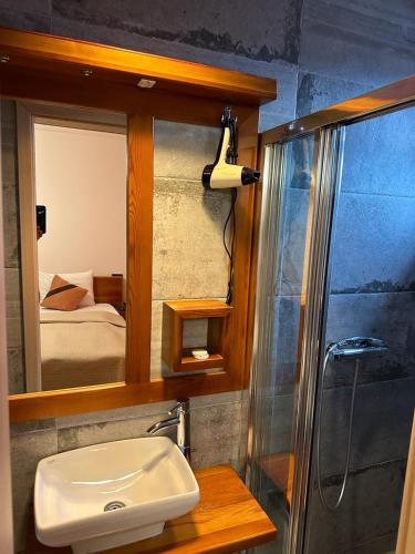 a bathroom with a sink and a shower and a mirror at Apartments Prizreni in Prizren
