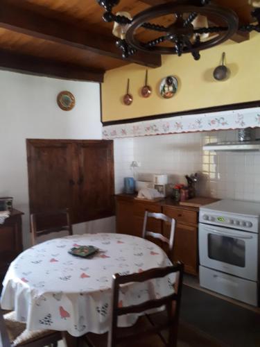 une cuisine avec une table et une cuisinière four supérieur dans l'établissement La maison de Juliette En haut, à Lascabanes