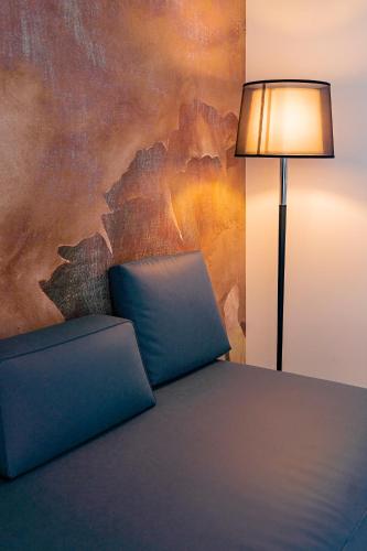 a bedroom with a bed and a lamp at GARNI' FOCI in Riva del Garda