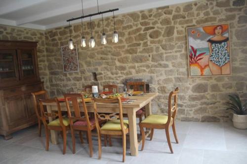 une salle à manger avec une table et des chaises en bois dans l'établissement « La maison de vacances » à 50 mètres de la plage, à Sibiril