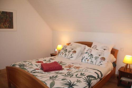 une chambre avec un lit avec un couvre-lit fleuri dans l'établissement « La maison de vacances » à 50 mètres de la plage, à Sibiril