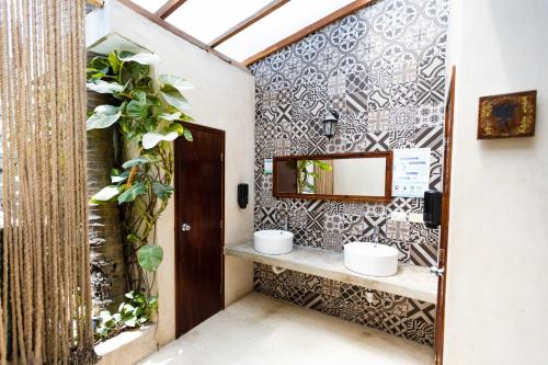 a bathroom with a sink and a mirror on a wall at Hotel Siesta Holbox in Holbox Island