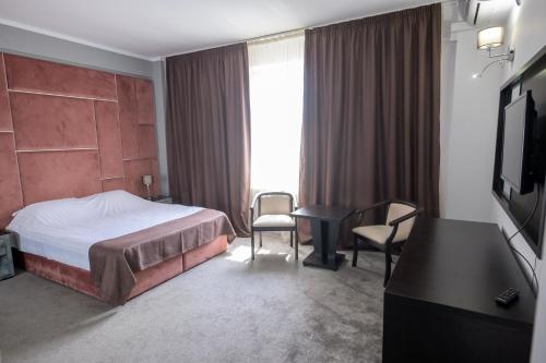 a hotel room with a bed and a table and chairs at Hotel Maryiotis in Constanţa