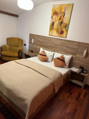 a bedroom with a large bed and a chair at Apartments Prizreni in Prizren