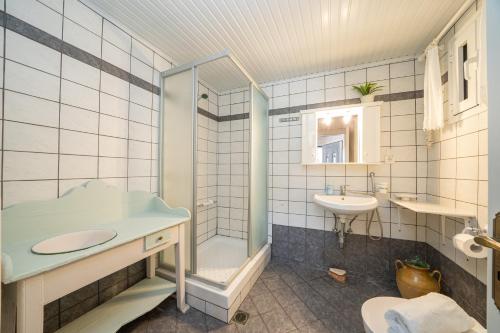 a bathroom with a glass shower and a sink at Dellaporta's Cottage in Makriótika