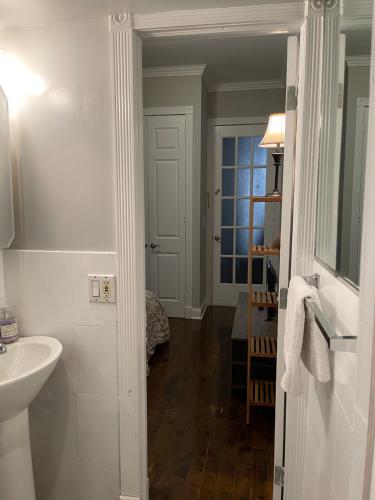 Baño blanco con lavabo y espejo en Private one bedroom one bathroom, en Nueva York