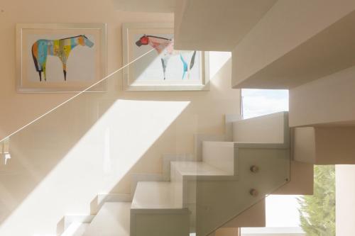 a staircase with two paintings of horses on the wall at Lux Villa Mia with Heated Pool, 2km to Beach & Childrens Area! in Mikro Metochi