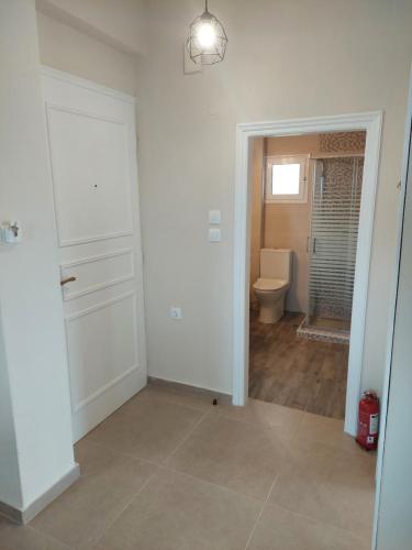 uma casa de banho vazia com um WC e uma porta em Kastro Apartments em Kalivia Poligirou