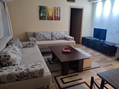 ein Wohnzimmer mit einem Sofa und einem Tisch in der Unterkunft Apartment Mica Old Town in Sarajevo