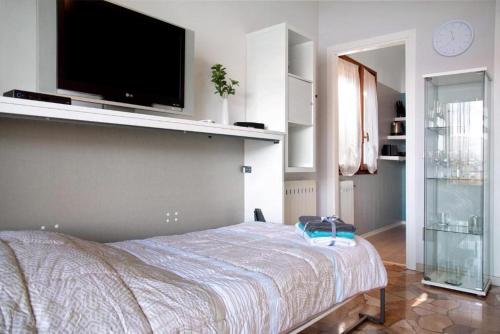 a bedroom with a bed with a flat screen tv on the wall at Ferienwohnung Studio Belvedere in Brezzo