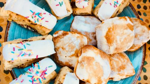 a plate of donuts with white frosting and sprinkles at B&b Domo La Laguna in Càbras