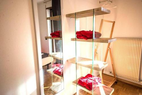 une pièce avec une étagère en verre avec des objets rouges dans l'établissement Riva Take It Easy, à Riva del Garda