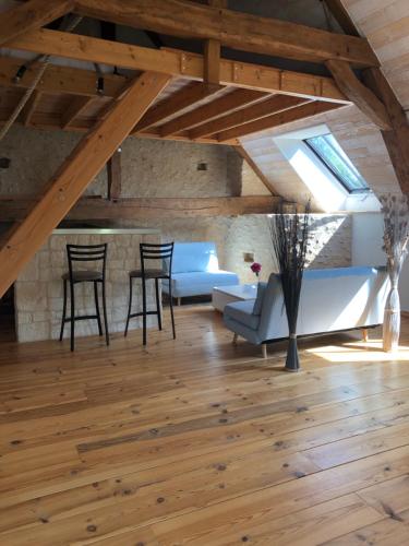 a living room with wooden floors and a vaulted ceiling at La Parenthèse - Studio atypique - Piscine - Proche Le Mans in Amné-en-Champagne