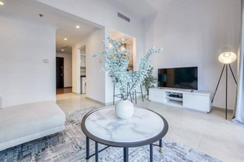 a living room with a couch and a table and a tv at Luxury 1 Bedroom Marina View, Sleeps 6, 1 Min to Metro in Dubai