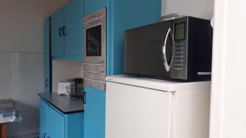 un micro-ondes au-dessus d'un réfrigérateur dans une cuisine dans l'établissement Maison de vacances familiale, à La Rochelle