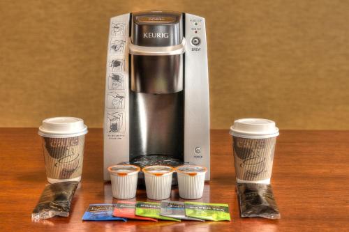 a coffeemaker and three cups of coffee on a table at The Ramsey Hotel and Convention Center in Pigeon Forge