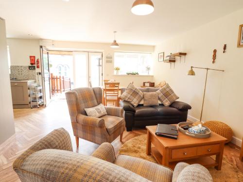 a living room with a couch and chairs and a table at Varley Villa in Newtown