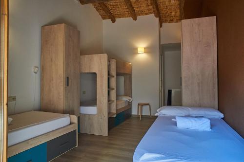 a bedroom with two beds and wooden cabinets at Lo Molí de Bot in Bot
