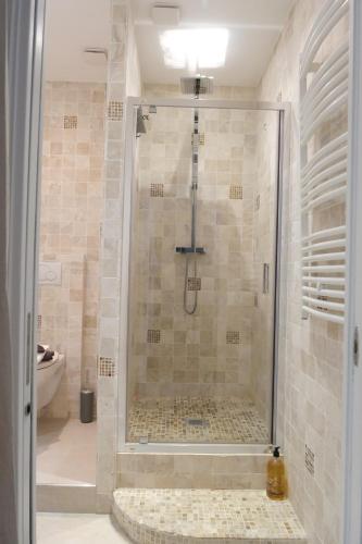 une salle de bain avec une douche avec une porte vitrée dans l'établissement sunside cannes, à Cannes