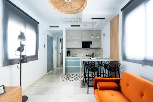 un soggiorno con divano arancione e una cucina di Alf8 Apartamento en Triana con dos terrazas a Siviglia