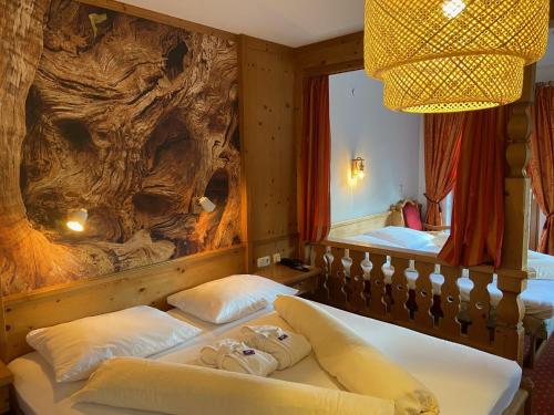 a bedroom with two beds and a rock wall at Scharler's Hotel in Uttendorf