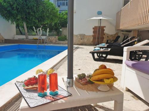 a tray of fruit on a table next to a pool at SUITE ROSETTA in Valenzano