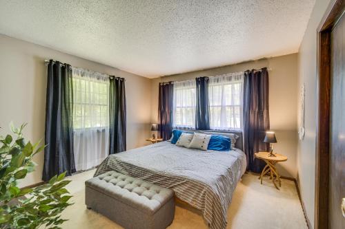1 dormitorio con cama, sofá y ventanas en Illinois Cabin with Wraparound Deck and Fireplaces, 