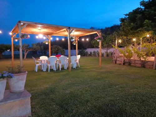 - une table et des chaises sous une pergola la nuit dans l'établissement Casa vacanze Salento: Villa Charlotte, à Torre Santa Susanna