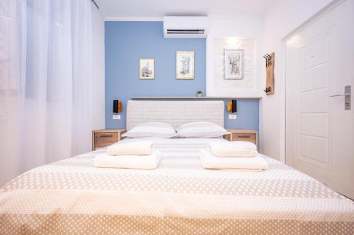 a bedroom with a large white bed with blue walls at Apartment Bosanska in Split