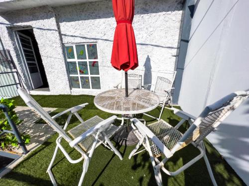 サン・ルイス・ポトシにあるLovely Loft 10 min from downtown - free parkingの赤い傘付きテーブルと椅子