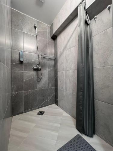 y baño con ducha y cortina de ducha. en Хостел Житомир GREEN HOUSE, en Zhytómyr