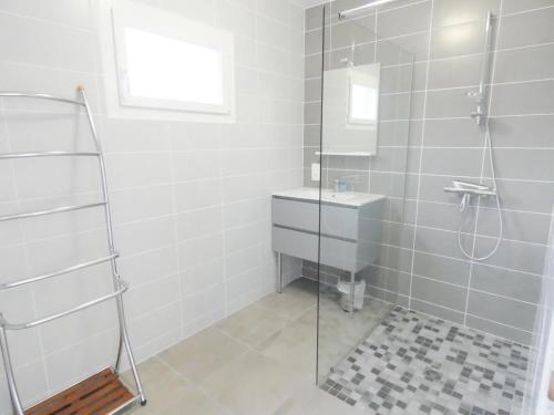 een badkamer met een glazen douche en een wastafel bij Pierron in Linxe