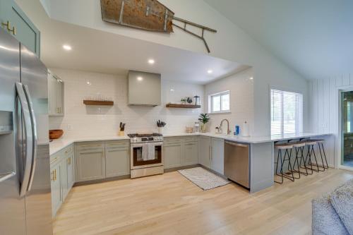 a large kitchen with stainless steel appliances and wood floors at Well-Appointed Tulsa Home with Fire Pit and Patio! in Tulsa