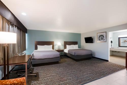 a hotel room with two beds and a desk at Quality Inn Fairfield Napa Valley Area in Fairfield