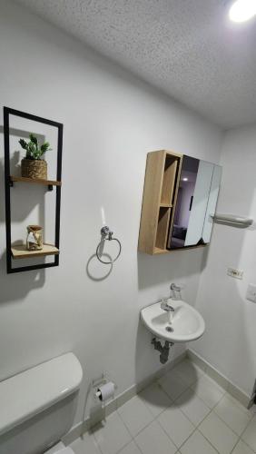 a white bathroom with a sink and a toilet at Apartasol Club Ciudadela Santa Fe - Santa Fe de Antioquia in Santa Fe de Antioquia