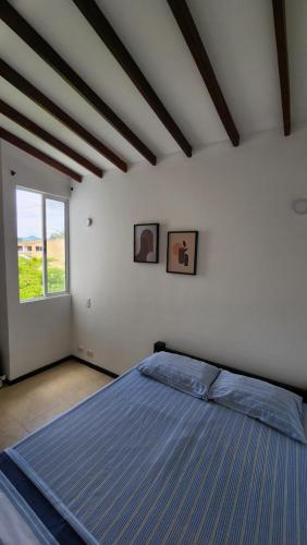 um quarto com uma cama grande e uma janela em Apartasol Club Ciudadela Santa Fe - Santa Fe de Antioquia em Santa Fe de Antioquia