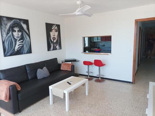 uma sala de estar com um sofá preto e dois bancos vermelhos em Apartment mit schöner Aussicht und Terasse em San Marcos