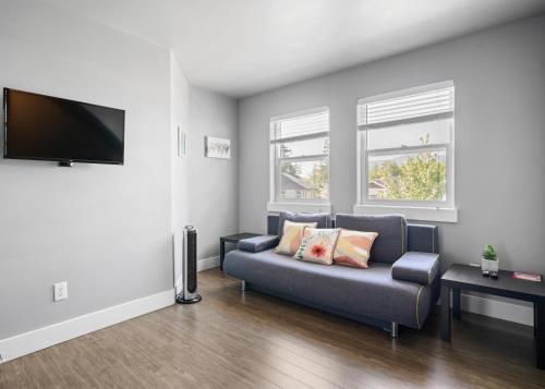 een woonkamer met een bank en een flatscreen-tv bij Separate Suite in Prestigious Linley Valley in Nanaimo