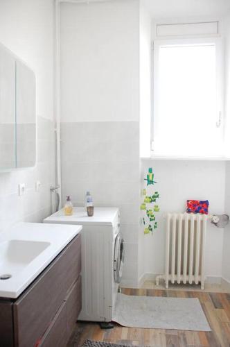 - une salle de bains blanche pourvue d'un lavabo et d'un radiateur dans l'établissement Appartement centre ville avec parking gratuit, à Chambéry