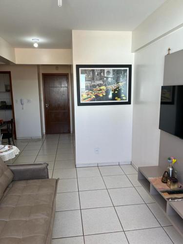 a living room with a couch and a picture on the wall at Apartamento Aconchegante no Centro 14 in Toledo