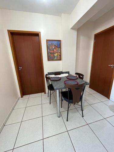 a dining room with a table and chairs and two doors at Apartamento Aconchegante no Centro 14 in Toledo