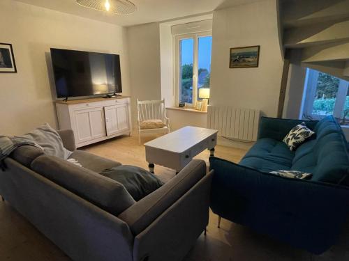 a living room with two couches and a flat screen tv at La Ferme du Raz Blanchard in Auderville