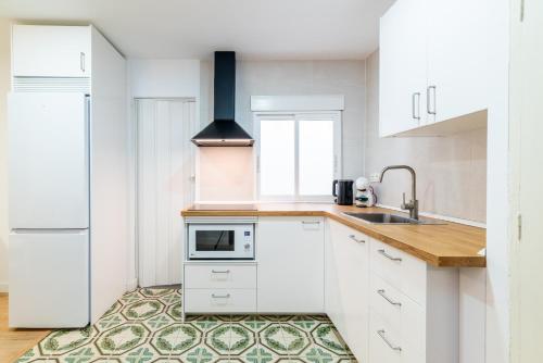 a kitchen with white cabinets and a sink at Modern Plaza de Toros Apartment with Free Parking in Granada