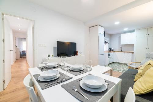 a dining room and kitchen with a white table and chairs at Modern Plaza de Toros Apartment with Free Parking in Granada