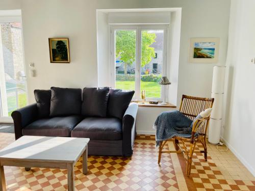 a living room with a couch and a table at La Ferme du Raz Blanchard in Auderville