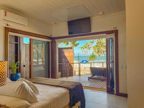 a bedroom with a bed and a balcony with a view at Hotel Nacional Inn Ubatuba - Praia das Toninhas in Ubatuba
