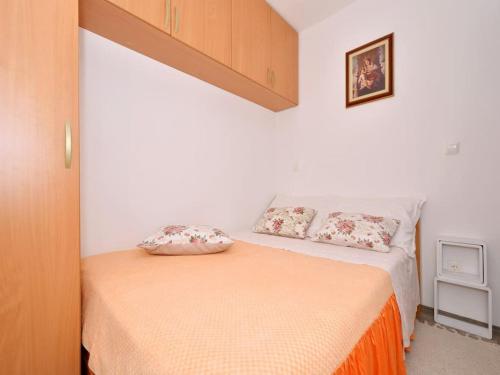a bedroom with a bed with two pillows on it at House with swimming heated pool next to the river in Podstrana