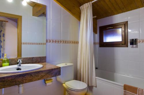 a bathroom with a toilet and a sink and a tub at Hostal Cal Mestre in Vilallonga de Ter