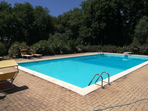 una gran piscina azul con 2 sillas y una mesa en Umbria Country B&B, en Giove